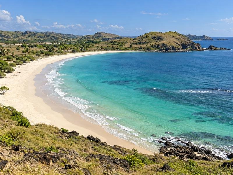 Curved shoreline and surrounding hills at Tanjung Aan Beach