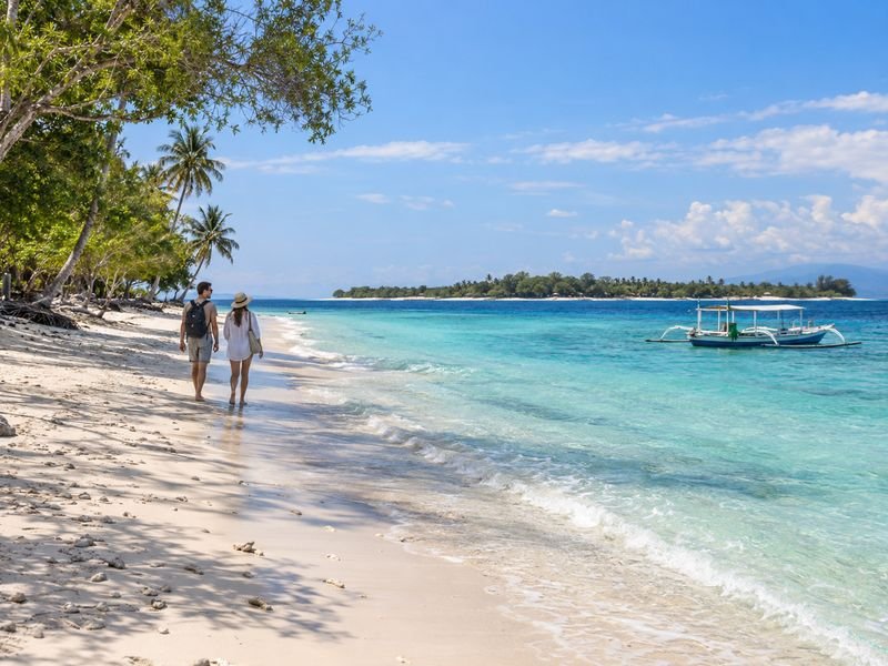 Travelers enjoying the quiet beach at Gili Meno